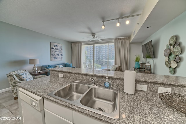 kitchen featuring a ceiling fan, a sink, a textured ceiling, open floor plan, and dishwasher