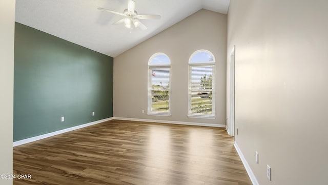 spare room with high vaulted ceiling, ceiling fan, baseboards, and wood finished floors