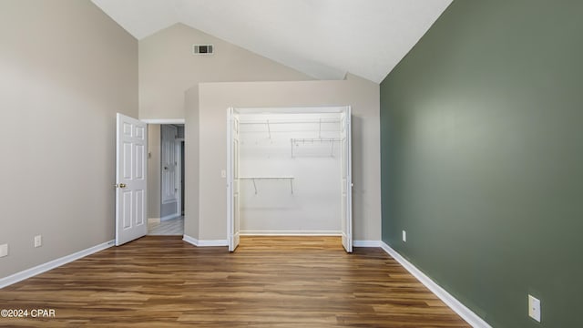 unfurnished bedroom with a closet, wood finished floors, visible vents, and baseboards