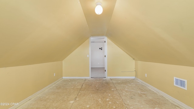 additional living space featuring lofted ceiling, visible vents, and baseboards