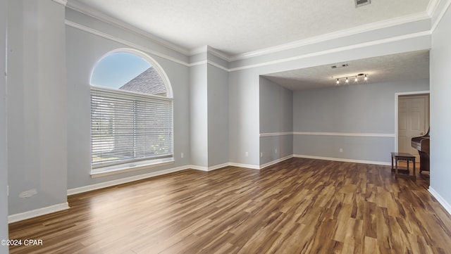 unfurnished living room with a wealth of natural light, crown molding, a textured ceiling, and wood finished floors