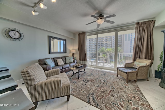 living room with a ceiling fan and a textured ceiling