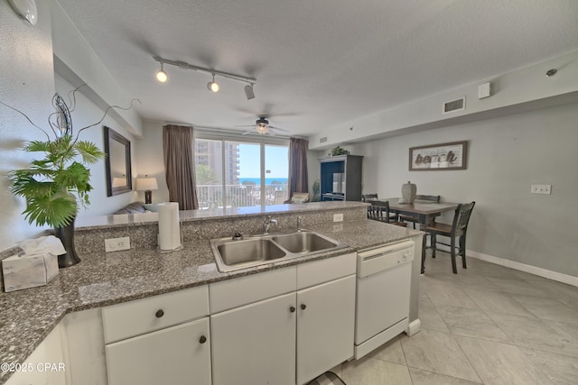 kitchen with visible vents, a sink, white cabinets, white dishwasher, and ceiling fan