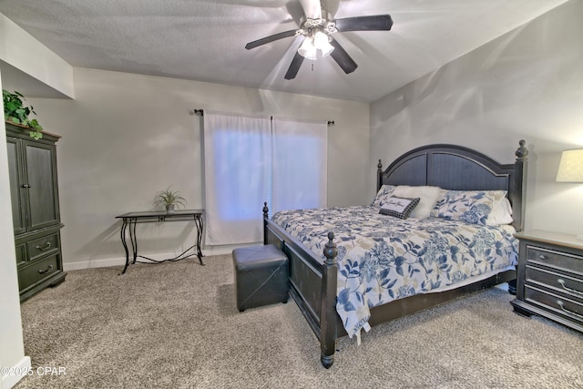 carpeted bedroom featuring a textured ceiling, baseboards, and ceiling fan