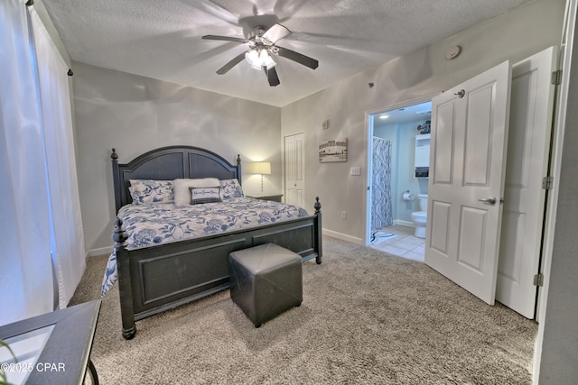 bedroom featuring ensuite bath, carpet flooring, baseboards, and a textured ceiling