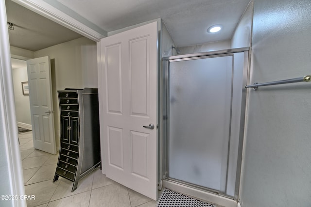 bathroom with tile patterned flooring and a shower stall