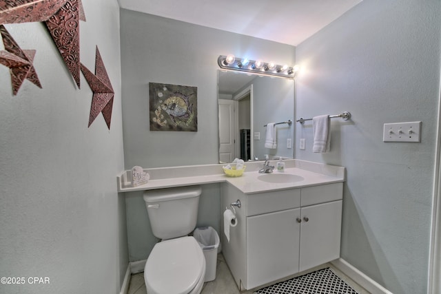 half bathroom featuring vanity, toilet, and baseboards