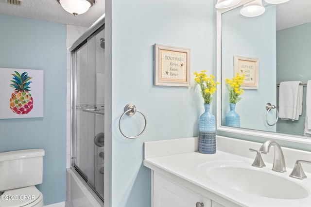 full bath featuring a textured ceiling, toilet, bath / shower combo with glass door, visible vents, and vanity