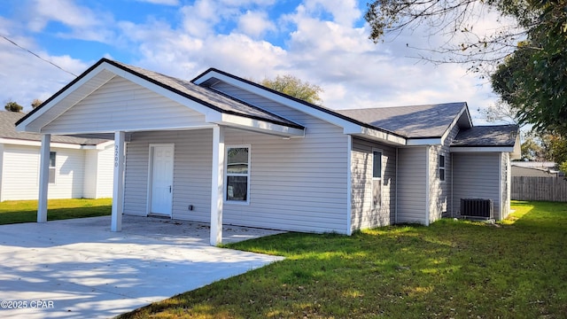 exterior space with concrete driveway, central air condition unit, a lawn, and fence