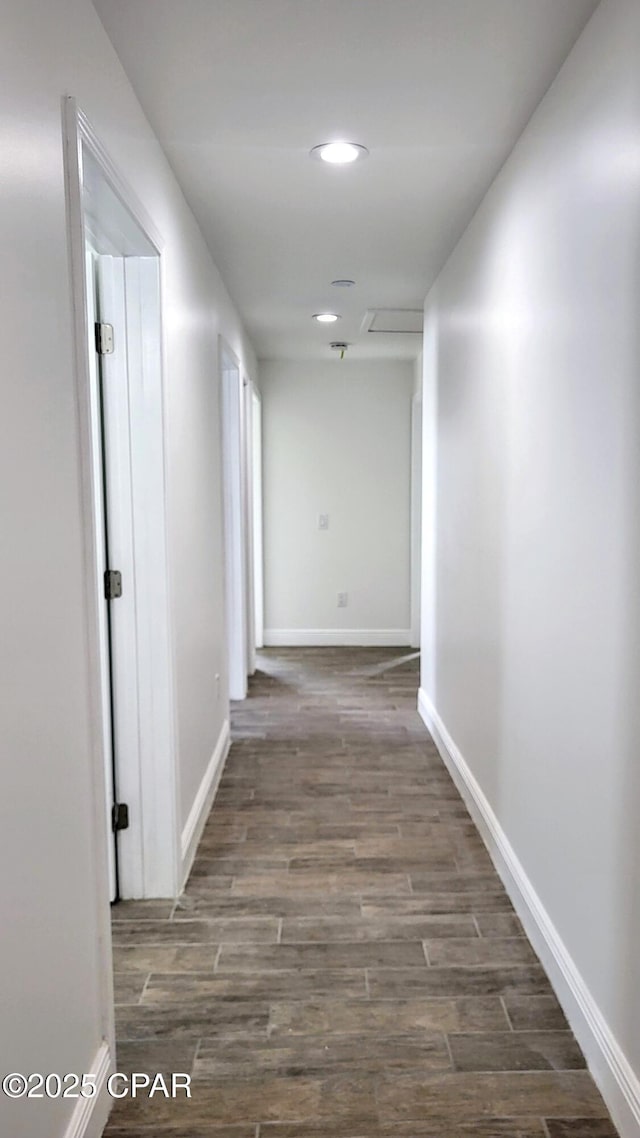 hallway featuring recessed lighting, baseboards, and wood finished floors