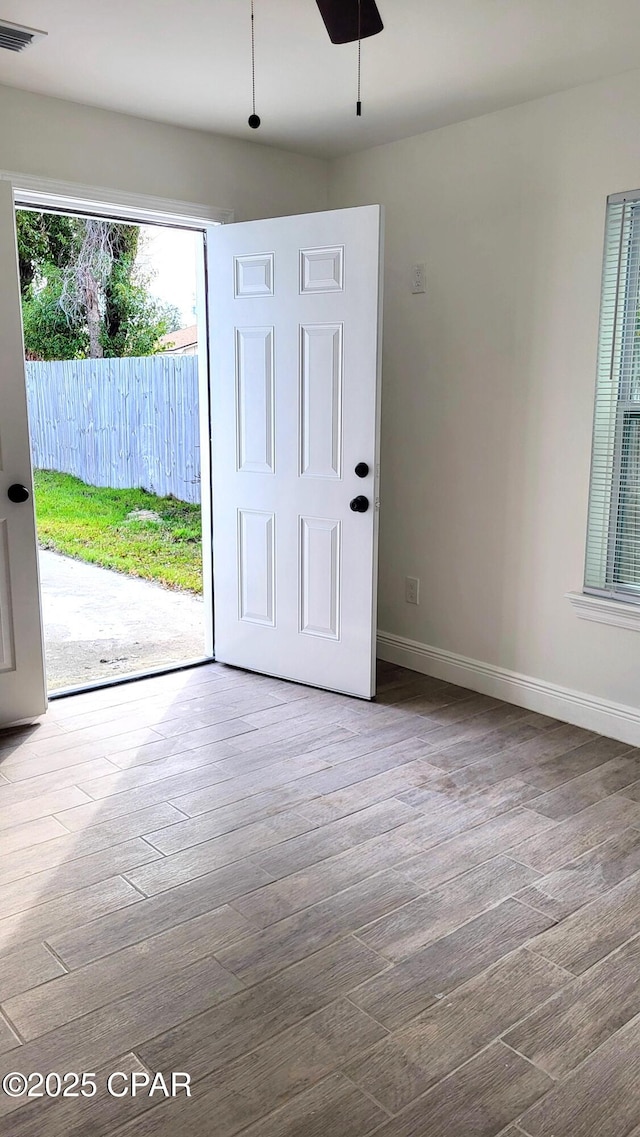 interior space with wood finished floors, visible vents, and baseboards