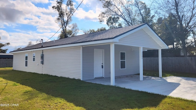 exterior space featuring a patio, a lawn, a carport, and fence