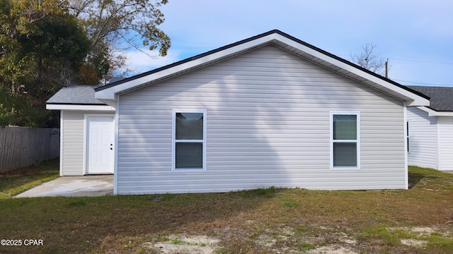 rear view of property featuring a yard and fence