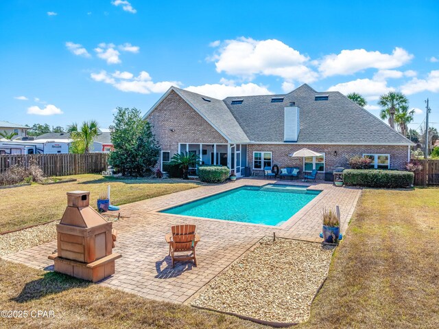 view of pool featuring a patio area, a lawn, a fire pit, and fence