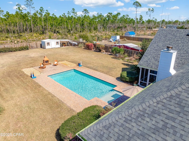 view of pool featuring an outdoor structure, a fenced backyard, a fenced in pool, a patio area, and a lawn