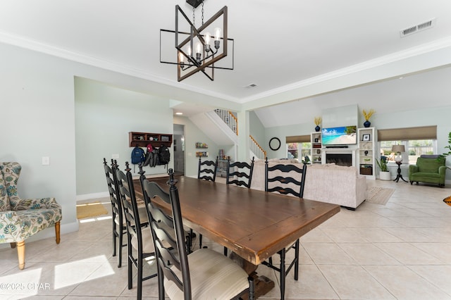 dining room featuring a fireplace, light tile patterned floors, stairs, visible vents, and ornamental molding