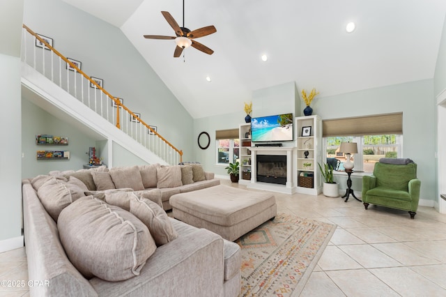 living area with light tile patterned floors, a ceiling fan, high vaulted ceiling, and plenty of natural light
