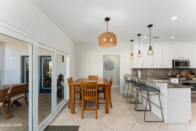 dining area featuring light tile patterned floors and recessed lighting