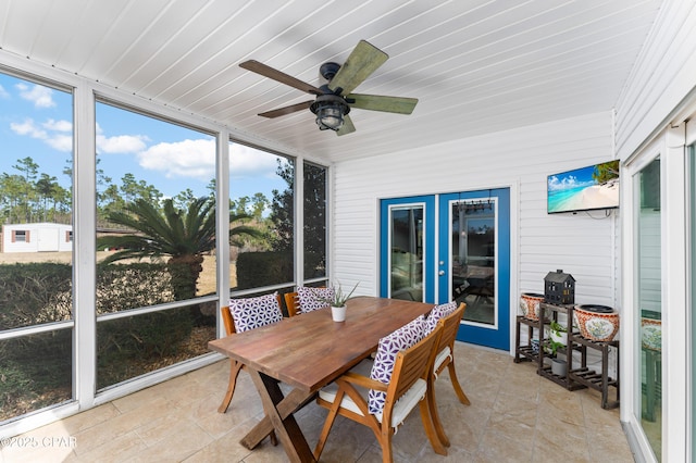sunroom / solarium with outdoor dining space and a ceiling fan