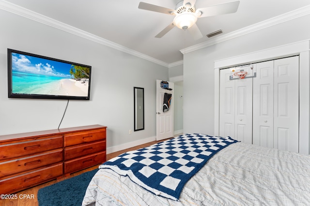 bedroom featuring crown molding, ceiling fan, visible vents, a closet, and baseboards