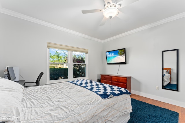 bedroom featuring wood finished floors, a ceiling fan, ornamental molding, and baseboards