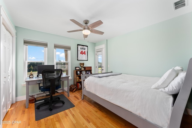 bedroom with visible vents, light wood-type flooring, a ceiling fan, and baseboards