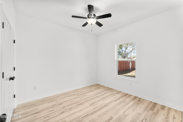 spare room with light wood-style floors, baseboards, and a ceiling fan