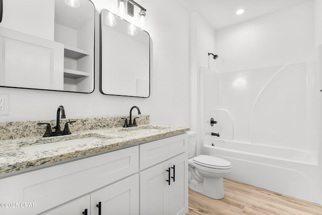 full bathroom featuring double vanity, a sink, toilet, and wood finished floors
