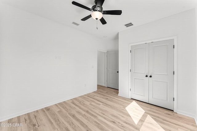 unfurnished bedroom with visible vents, light wood-style flooring, a closet, and baseboards