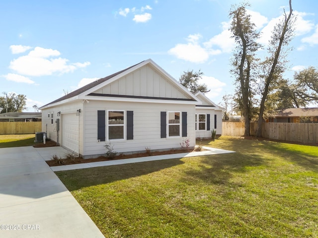 view of front of home with board and batten siding, a front lawn, fence, and concrete driveway