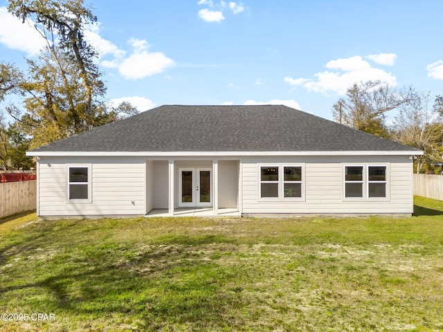 back of house featuring french doors, a shingled roof, fence, and a lawn