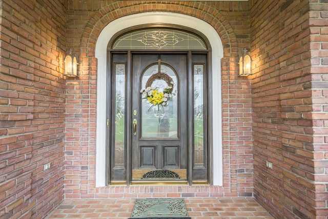 property entrance featuring brick siding