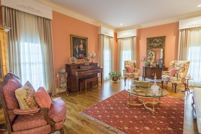 sitting room with wood finished floors and ornamental molding