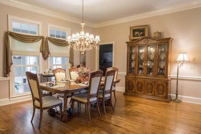 dining area featuring light wood-style flooring, baseboards, an inviting chandelier, and ornamental molding