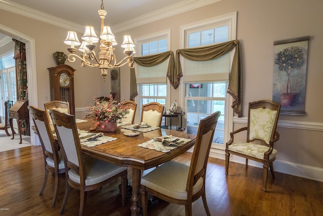 dining space featuring a chandelier, crown molding, baseboards, and wood finished floors