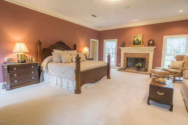 carpeted bedroom featuring crown molding, a brick fireplace, multiple windows, and visible vents