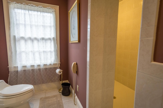 bathroom featuring tile patterned floors, toilet, a tile shower, and a wealth of natural light