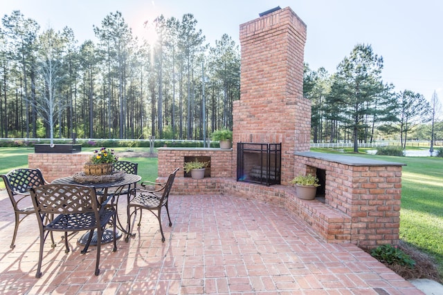 view of patio / terrace featuring outdoor dining area and an outdoor brick fireplace