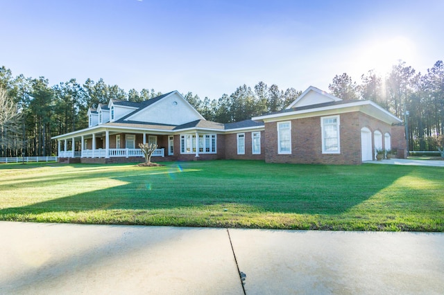 view of front of home with a porch, an attached garage, brick siding, and a front lawn