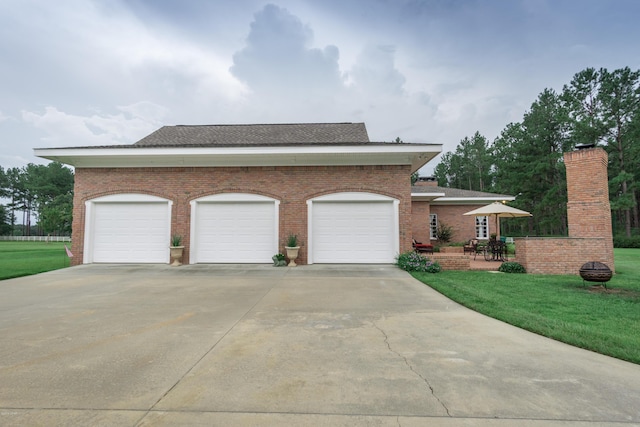 view of front of house featuring brick siding, an attached garage, concrete driveway, and a front lawn