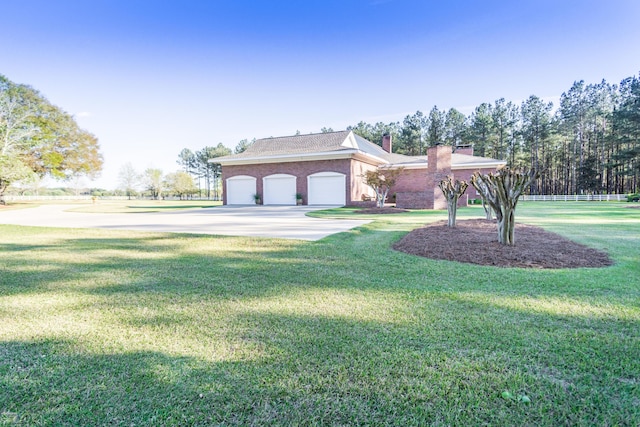 view of front of property with a chimney, a garage, concrete driveway, and a front yard