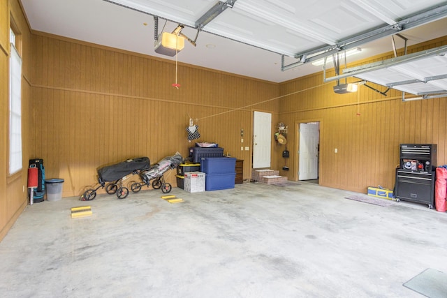 garage with wooden walls and a garage door opener