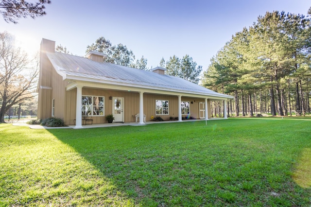 rear view of property with a lawn and metal roof