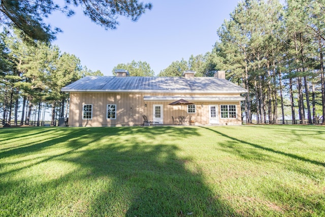 back of property featuring a lawn and a chimney