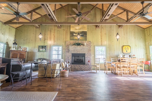 living area with a wealth of natural light, wood finished floors, a fireplace, and wood walls