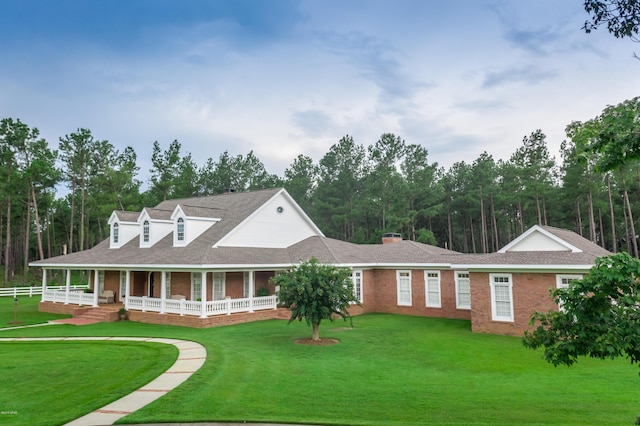 view of front of home with brick siding, a porch, and a front lawn