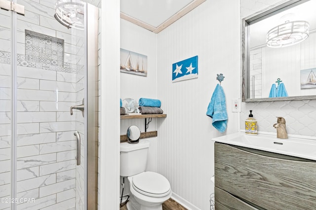 bathroom featuring vanity, a shower stall, crown molding, toilet, and tasteful backsplash