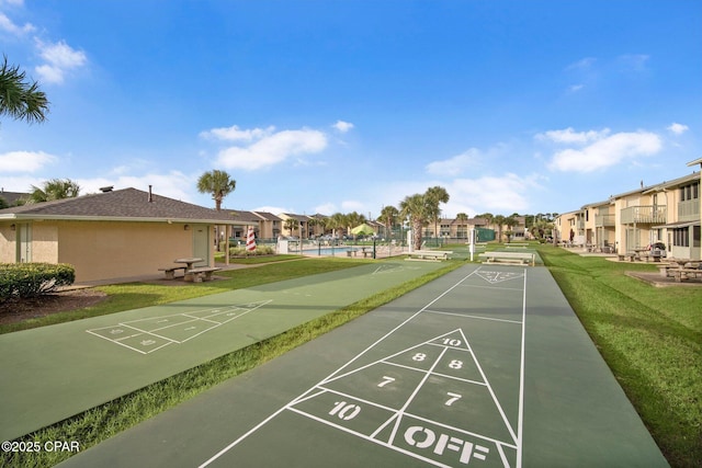 view of property's community featuring a residential view, a lawn, and shuffleboard