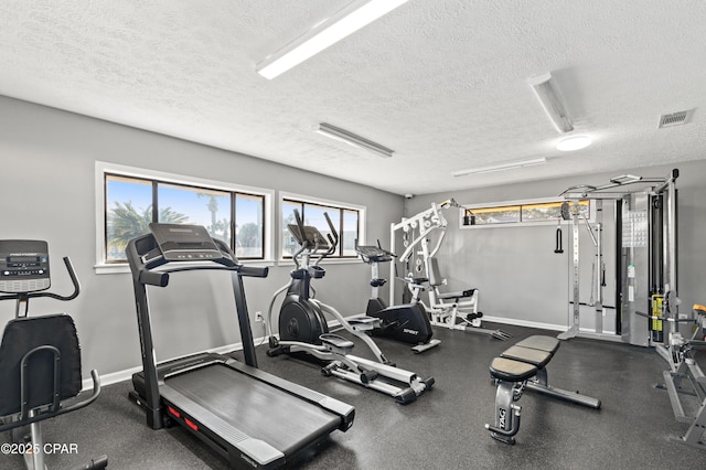 workout area with visible vents, baseboards, and a textured ceiling