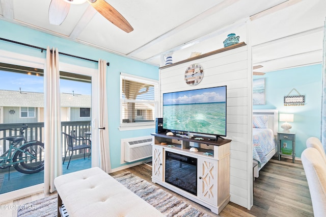 interior space featuring access to exterior, baseboards, wood finished floors, and a wall unit AC